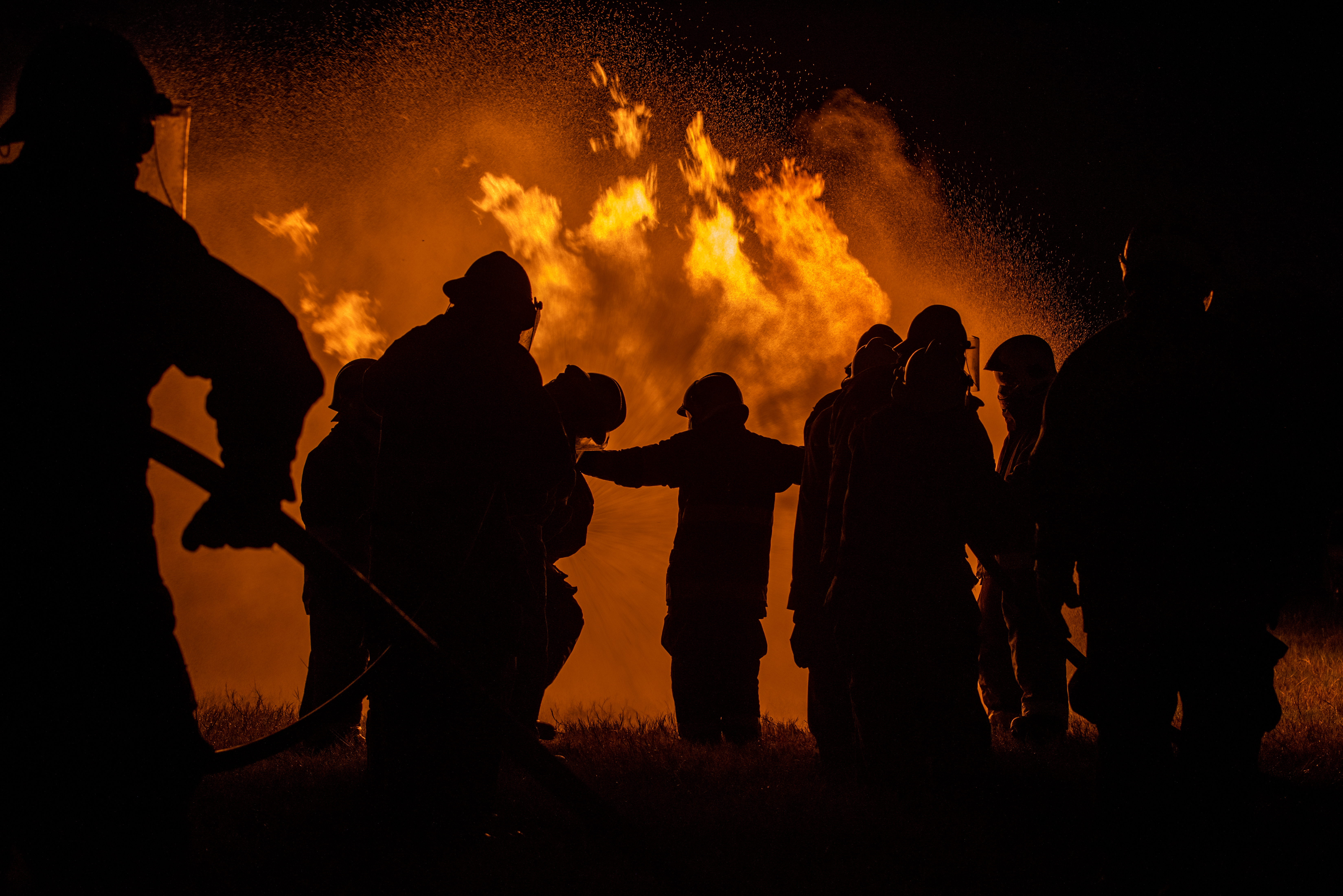 Firefighters working at night at the scene of a structure fire.